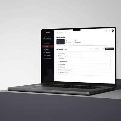 Laptop displaying a digital archive interface with folders and files organized in a clean document management dashboard.